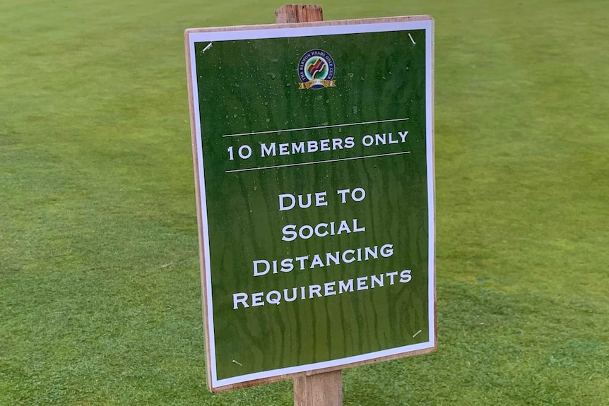 A sign on a golf fairway saying 10 members only due to social distancing requirements.