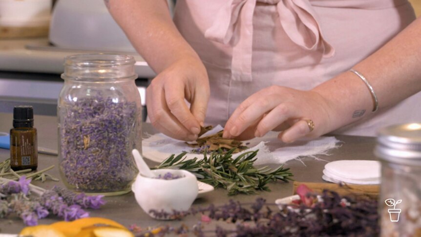 Hands wrapping dried flowers and plants in cloth