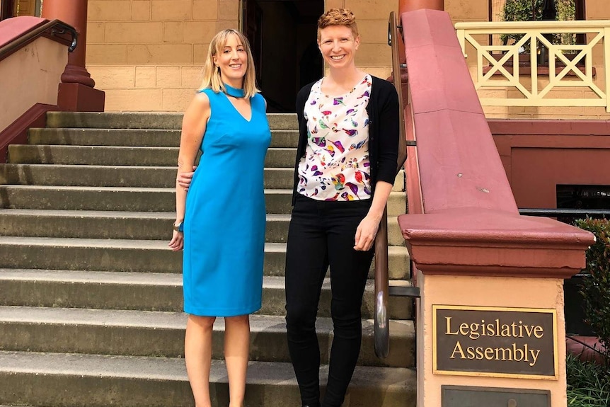 Two women stand outside parliament