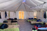 Inside one of the temporary crew tents with cot beds and air-conditioning for firefighters to rest.