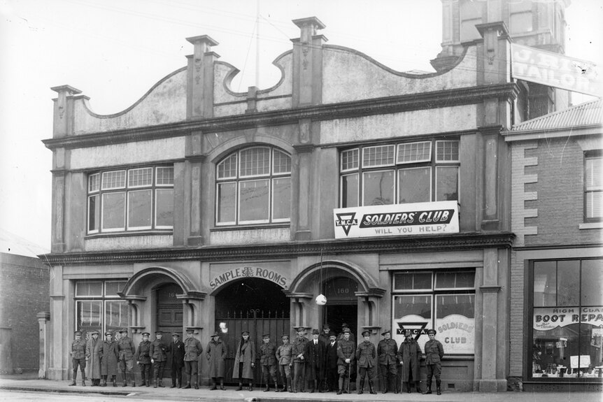 A black and white photo of 20 travelling salesmen lined up outside the CTA club in 1916.