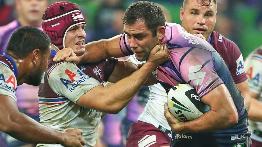 Melbourne's Cameron Smith is tackled by Manly's Matt Ballin at AAMI Park.