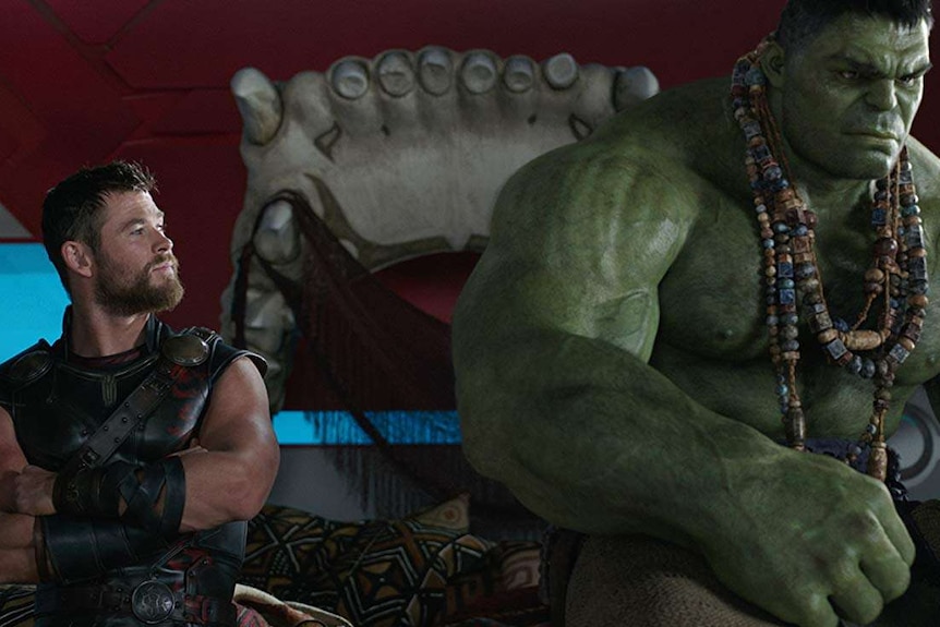 Thor and the Hulk sit on a giant bed made from a jaw.