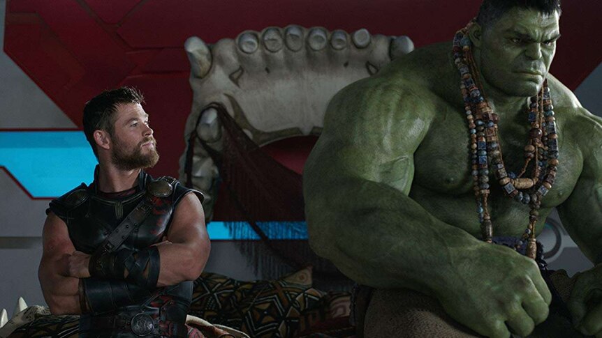 Thor and the Hulk sit on a giant bed made from a jaw.