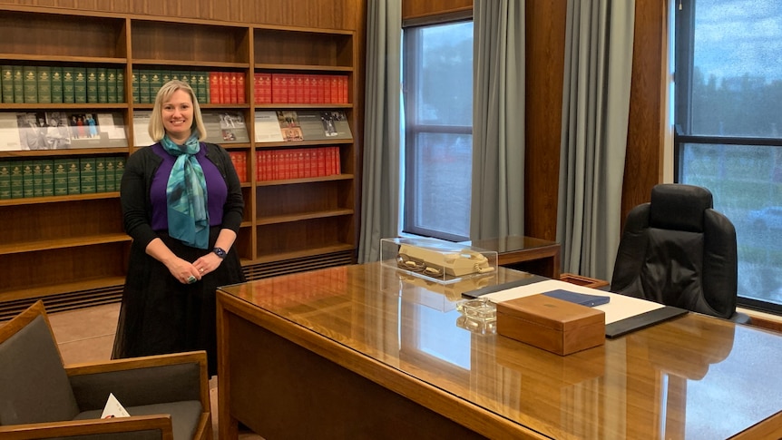 A woman stands in the prime minister's office at Old Parliament House