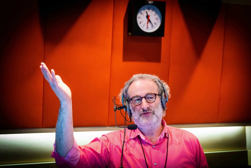 Radio host Jon Faine gestures in studio