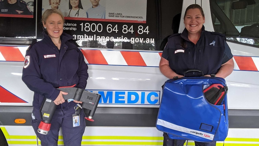Ambulance Victoria Paramedics Bernie Jordan and Erin Peers pose with the CPR machine in front of an ambulance