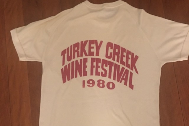 Image of a white t shirt with the words "turkey creek wine festival 1980" screen printed onto it.