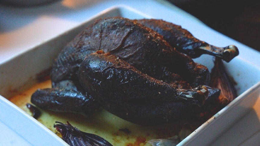 A cooked black skin chicken sits in a white bowl.