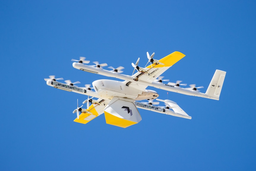 White and yellow drone in the sky.