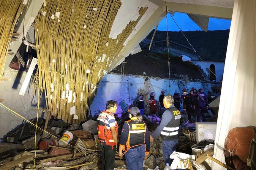 Abancay police, officers and firefighters stand by a collapsed area of the Alhambra hotel in Abancay, Peru.