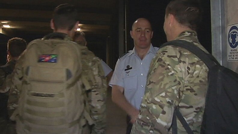 Group Captain Simon Sauer greets RAAF officers returning to Amberley Air Base.