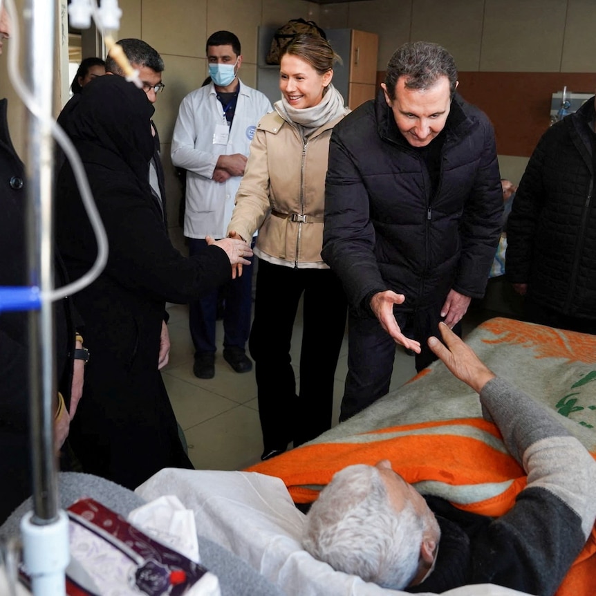 The Assads walk into a hospital room, greeted by staff