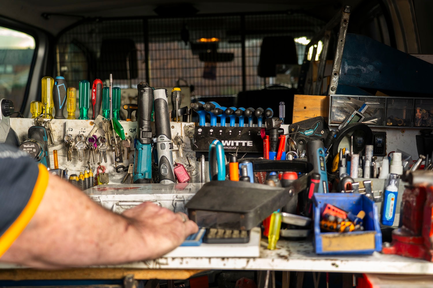 a board of keys and tools hanging in a locksmith van