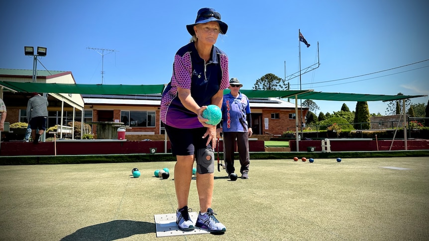 A woman takes part in a game of lawn bowls