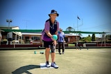 A woman takes part in a game of lawn bowls