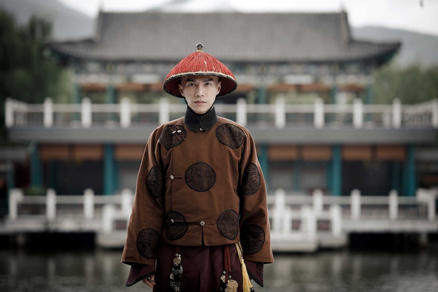 Lawrence Wong stands in front of a building in traditional Qing dynasty clothing during role for The Story of Yanxi Palace