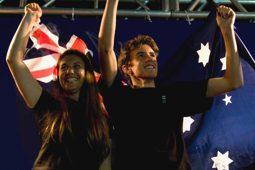 Lisa and Jason fly an Australian flag at the end of an event.