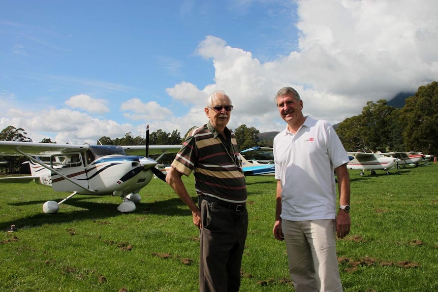 Owen Bartrop and Peter Jones from the Cessna Association Of Australia stand in front of a row of planes.