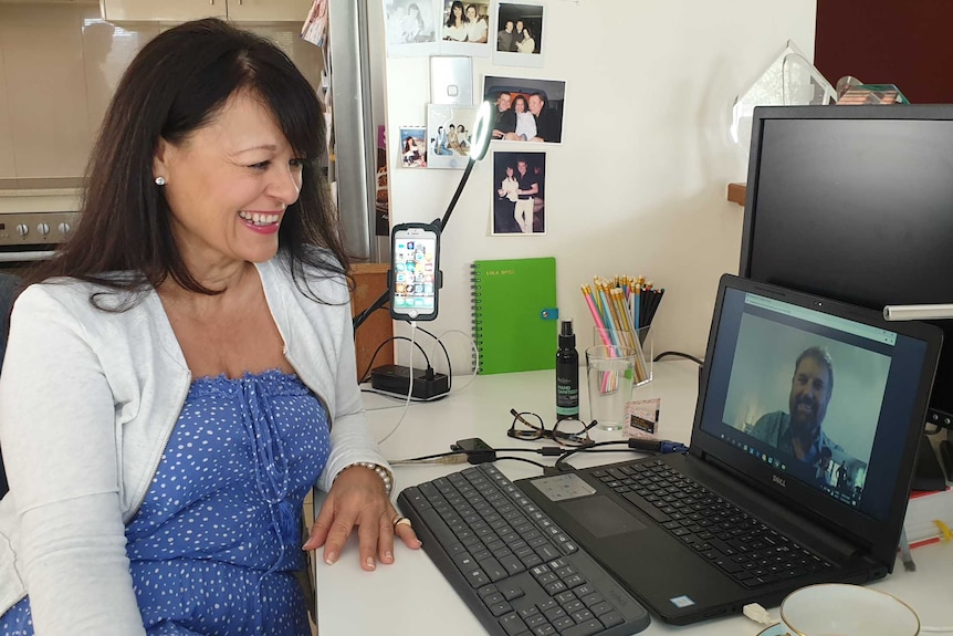 Laura Speirs sitting at a desk talks to Paul Gauger, seen on her laptop screen.