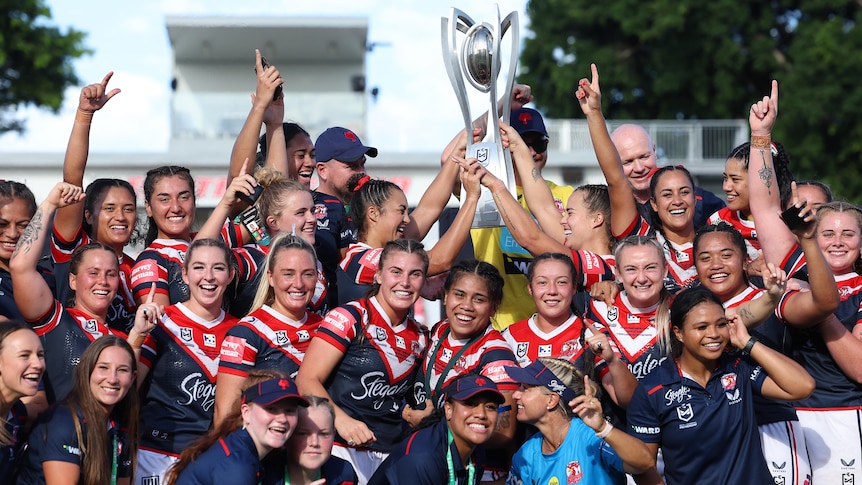 A group of rugby league players celebrate winning a premiership 