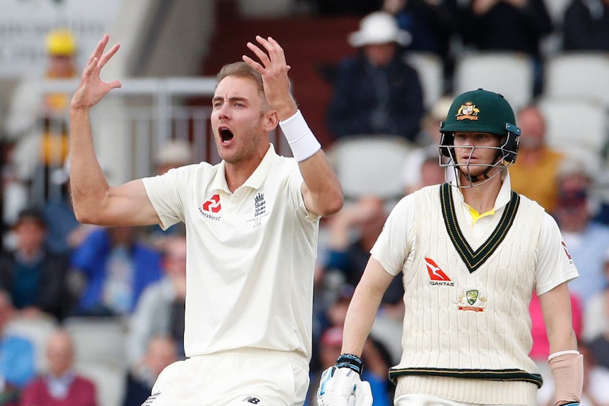 England bowler Stuart Broad shouts and puts both hands in the air as Australia batsman Steve Smith stands behind him.