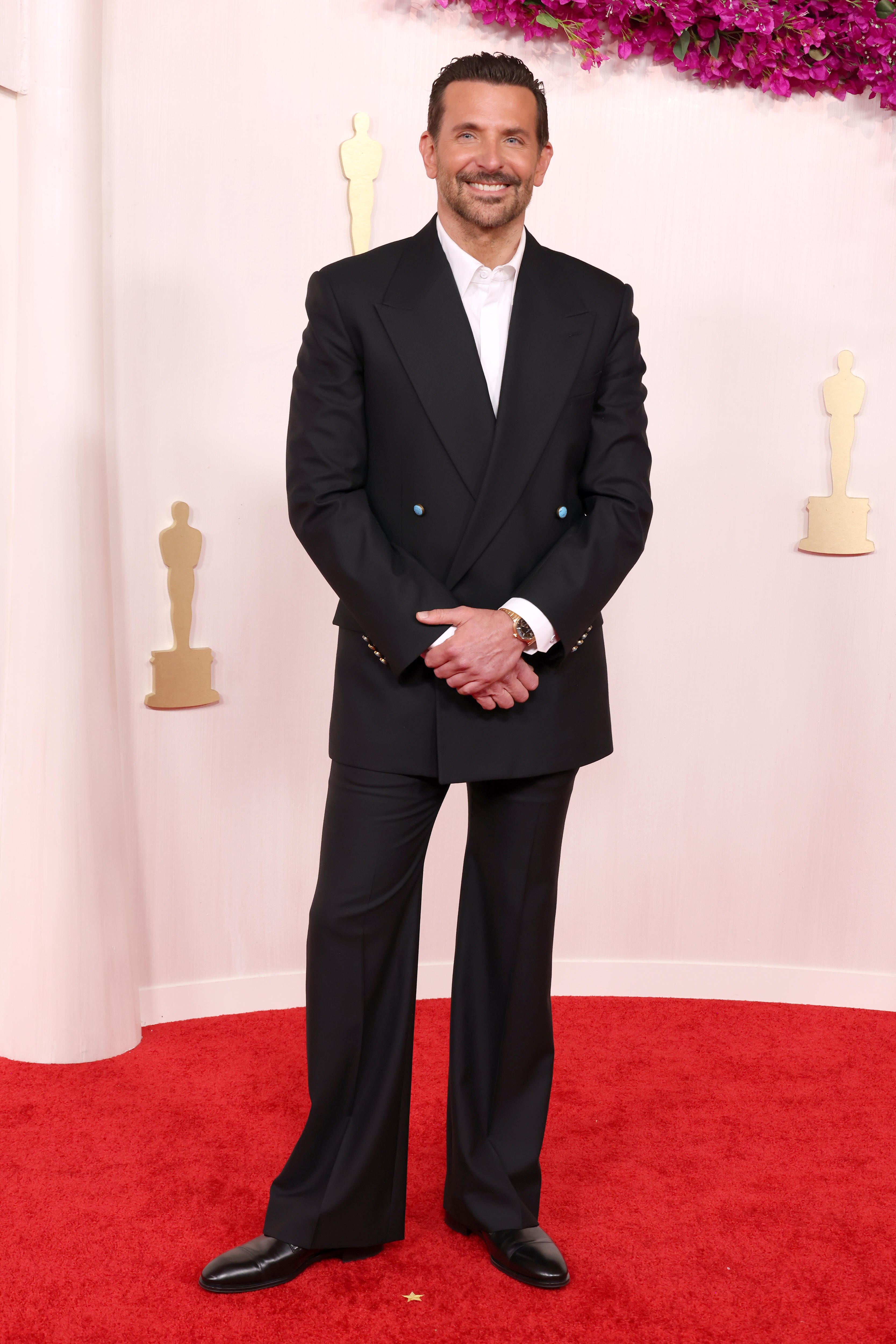 Bradley Cooper poses on the Oscars red carpet.