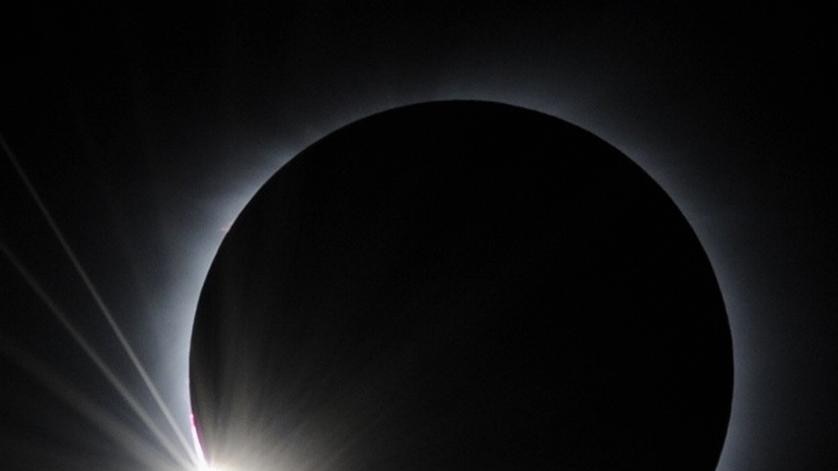 Moon almost completely covers the sun just before totality during a total solar eclipse