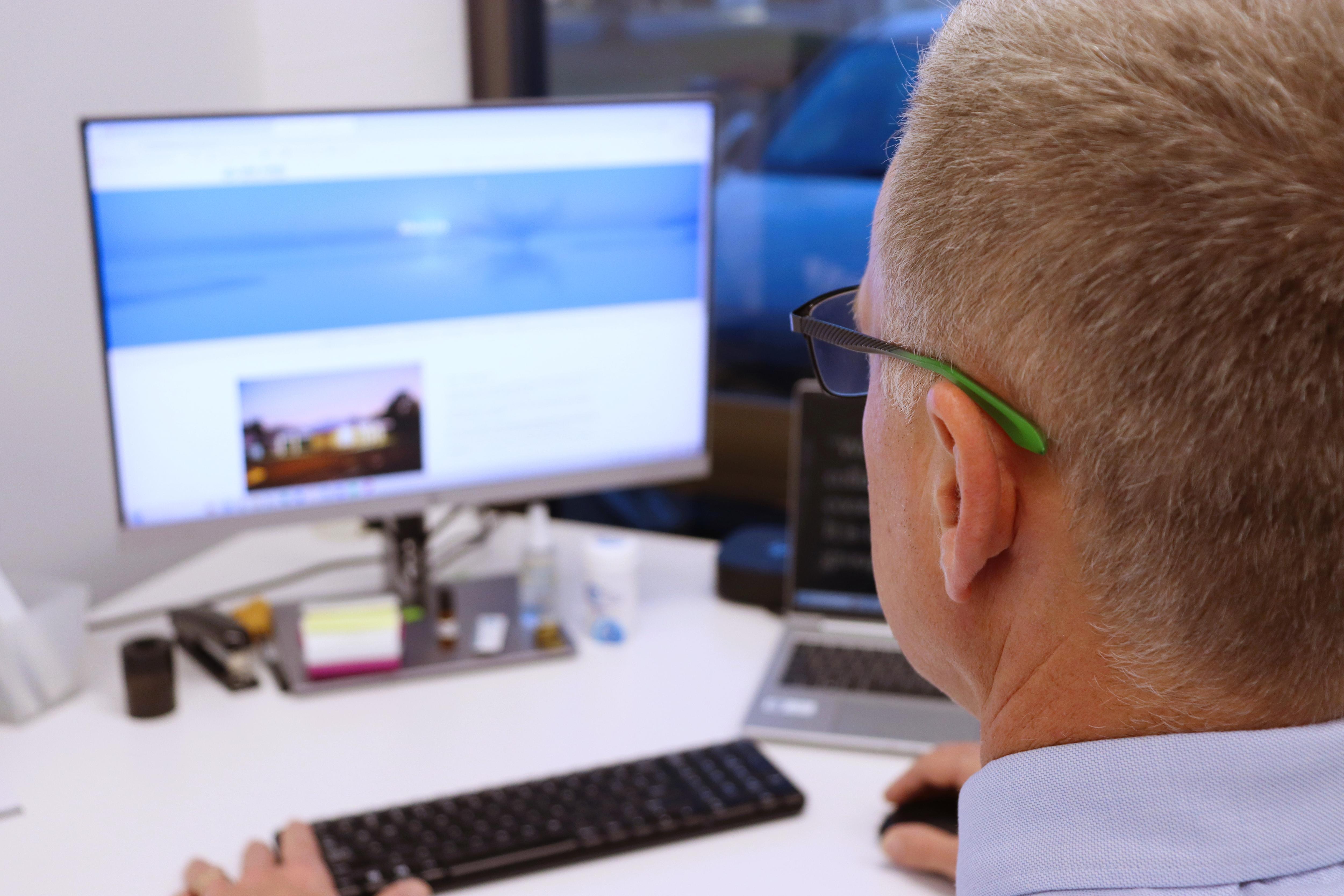 side of man's head looking at computer screen