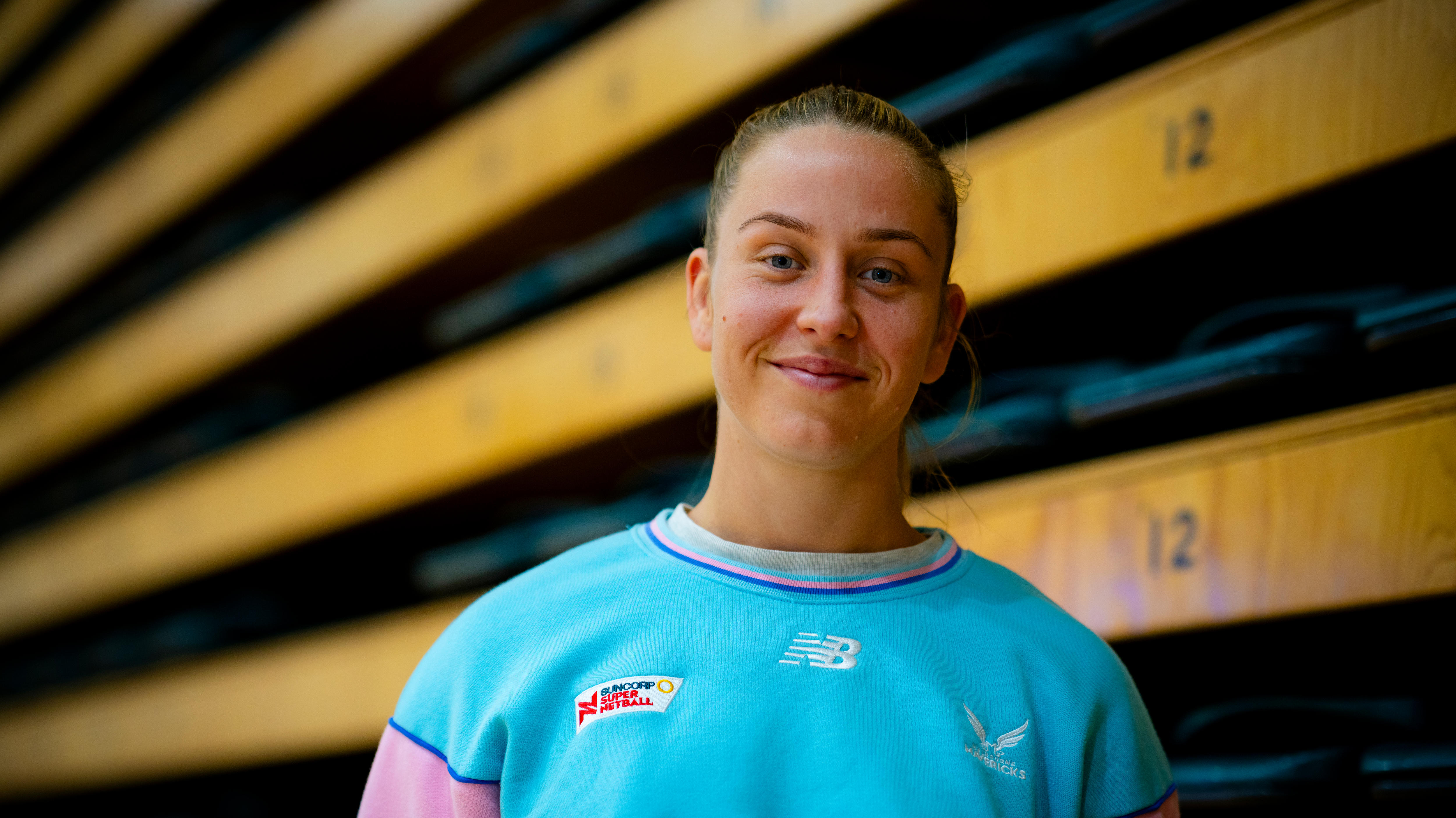 Woman in blue shirt smiles.