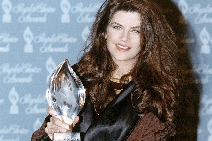 Actor Kirstie Alley in 1991 holds an award 