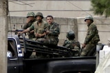 Syrian soldiers patrol the Syrian side of the border village of Arida.