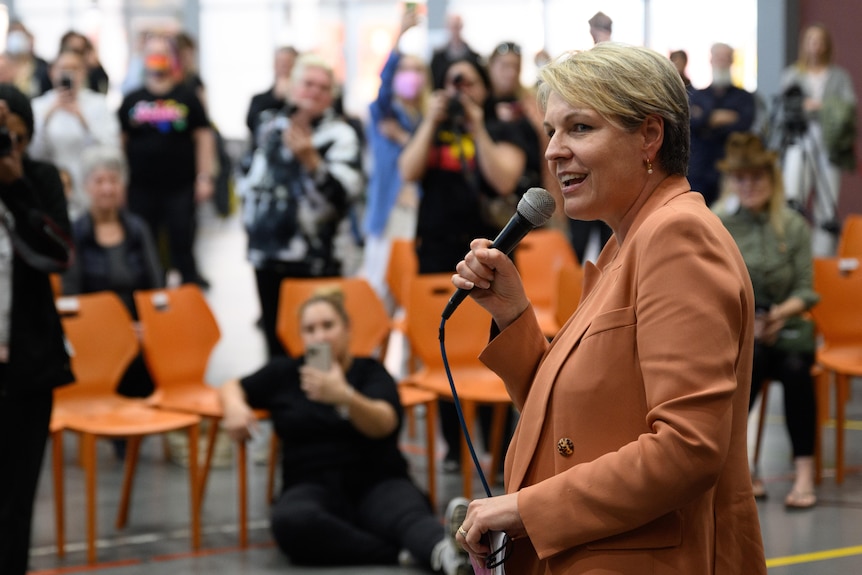 Tanya Plibersek holds a microphone and speaks to a crowd