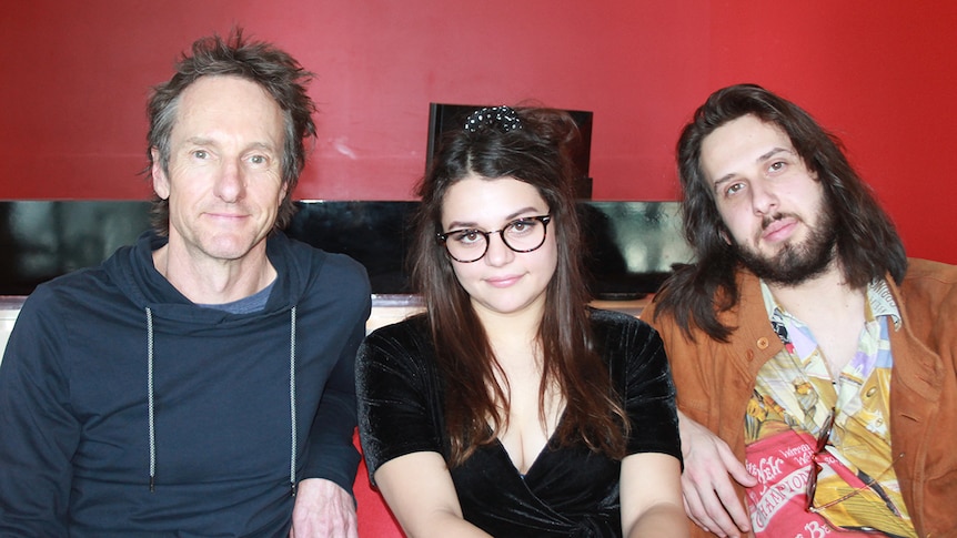 Photograph of Sophie and Ethan from Tired Lion sitting on a couch with Richard Kingsmill