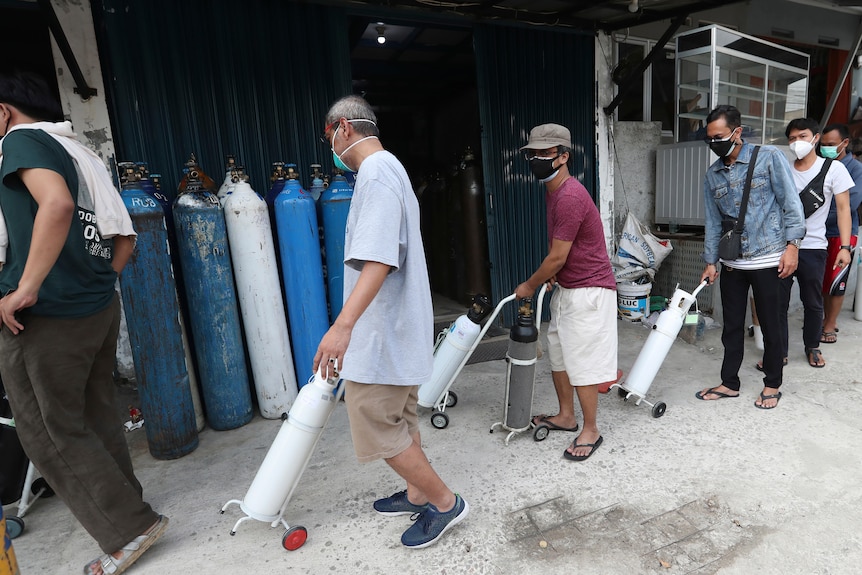 People line up to refill their oxygen tanks at a filling station in Jakarta