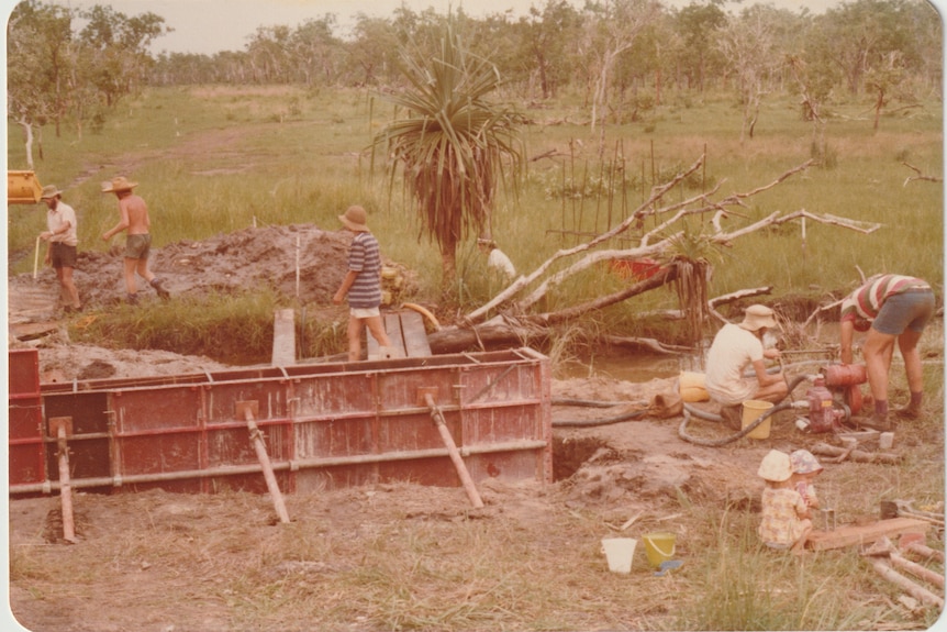 An old photo of a group of people helping build a solar array.
