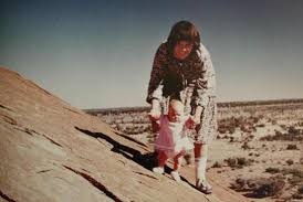 A mother and daughter on a large rock.