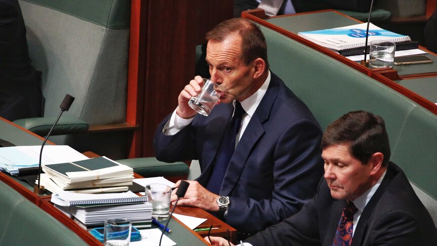 Former prime minister Tony Abbott drinks from a glass of water in Question Time