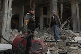 Free Syrian Army members near damaged buildings in Daraya