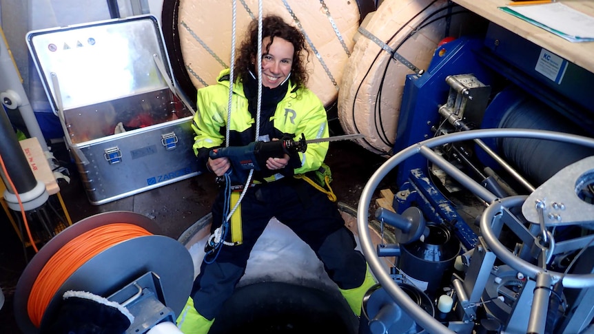 Dr Amelie Meyer cutting a hole in sea ice
