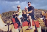 A family ride camels.