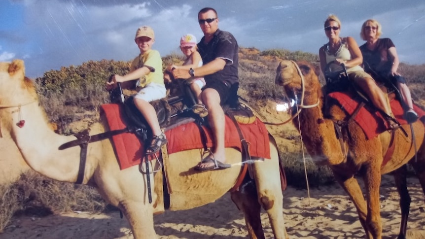 A family ride camels.