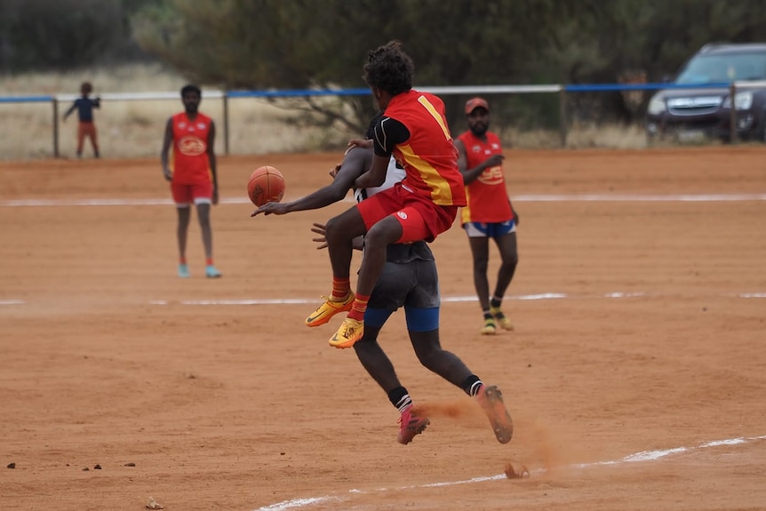 One player trying to take a mark over another player both players off the ground 