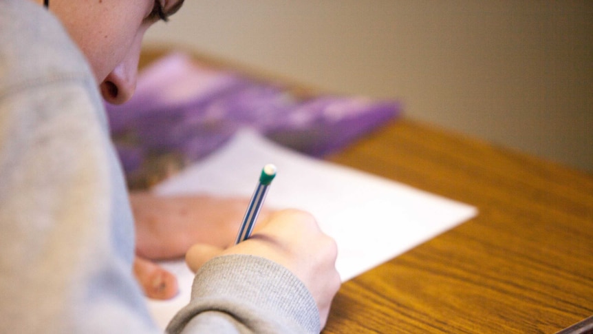 A person writing on a piece of paper