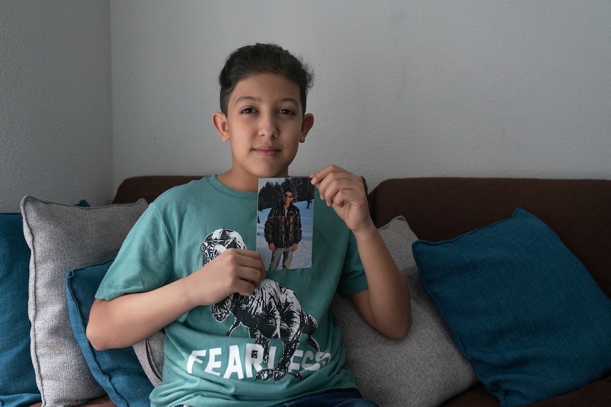 A boy with a photo of his dad.