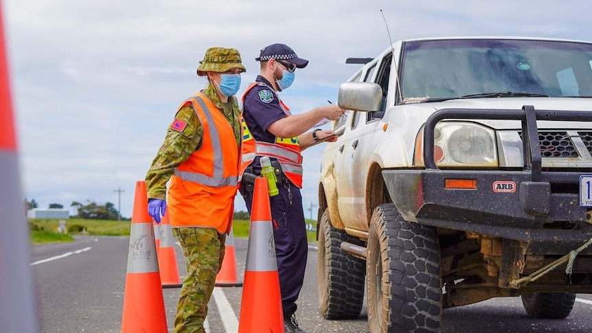 An ADF member and an SA Police officer at a checkpoint near the SA-Victoria border.