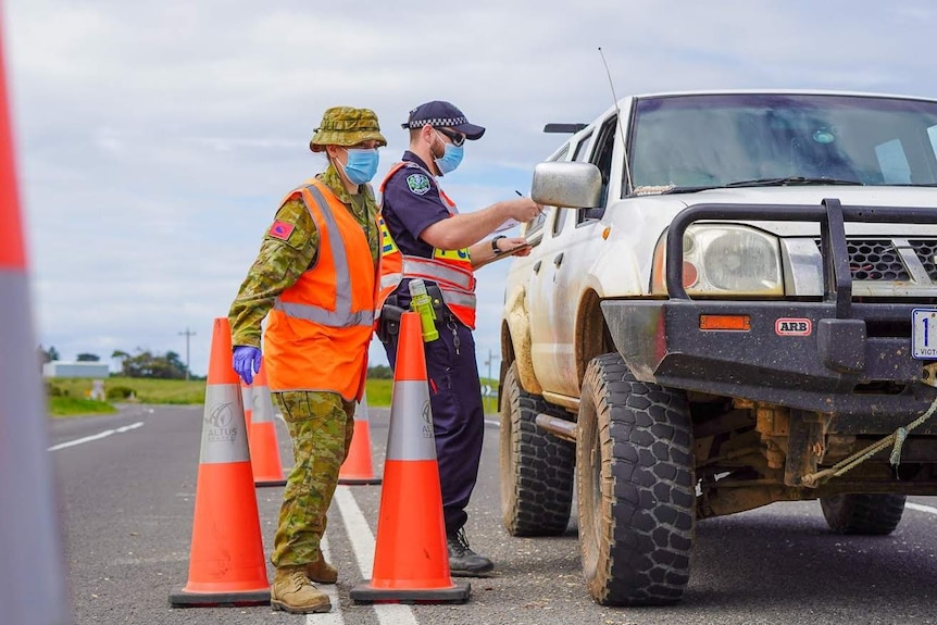 An ADF member and an SA Police officer at a checkpoint near the SA-Victoria border.