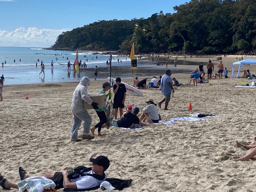 Man in hazmat suit at beach.