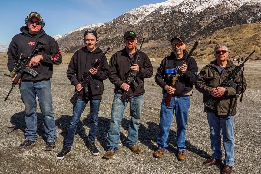 A line of men armed with guns in a wide valley in Utah
