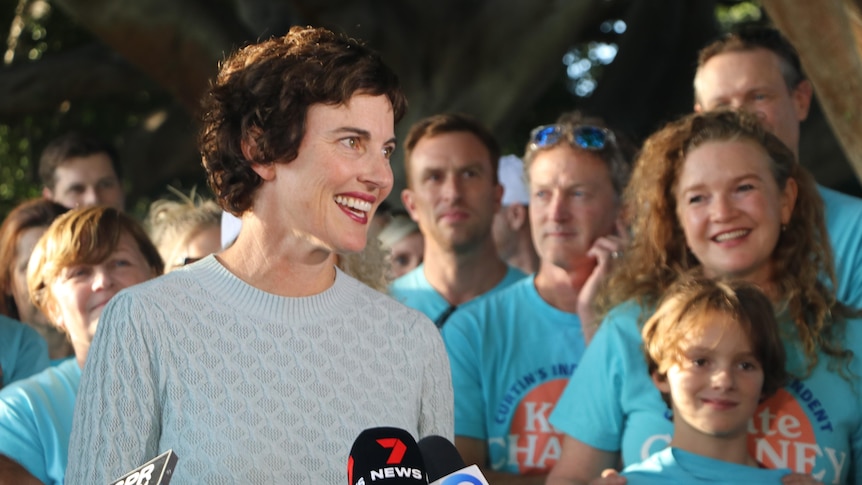 Kate Chaney is surrounded by supporters wearing teal shirts as she claims victory in the seat of Curtin